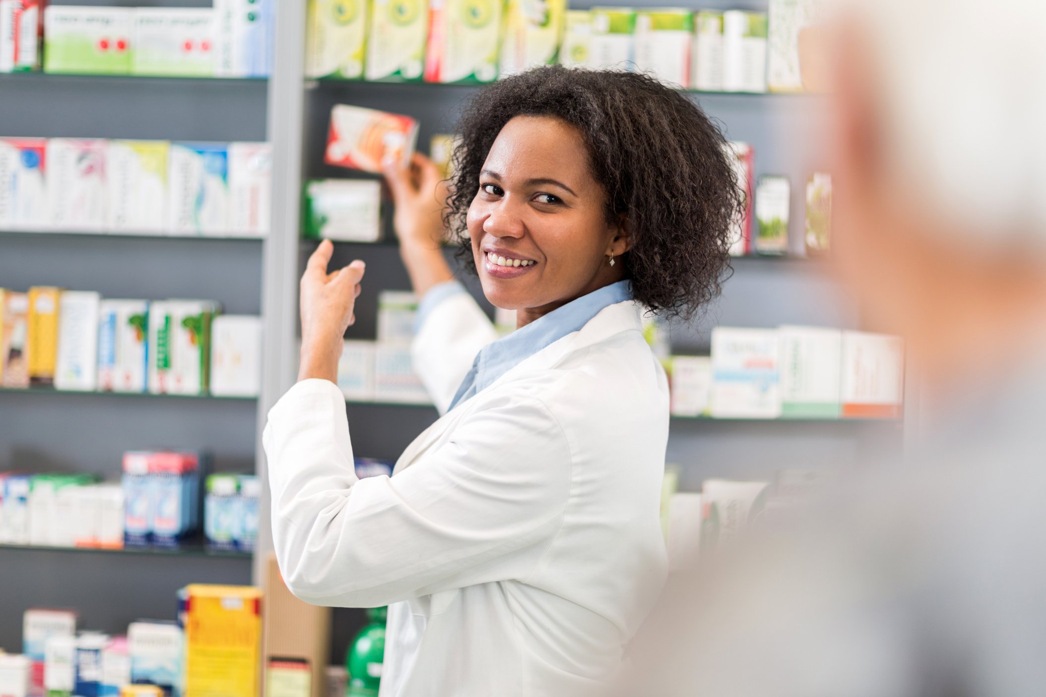 African American pharmacist serving customer in pharmacy.